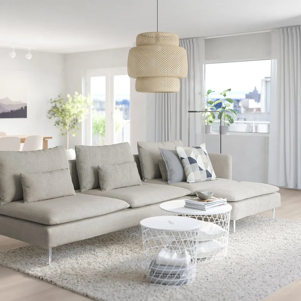 Modern living room with light grey SÖDERHAMN sofa, large cushions, white coffee table, and unique pendant lamp.