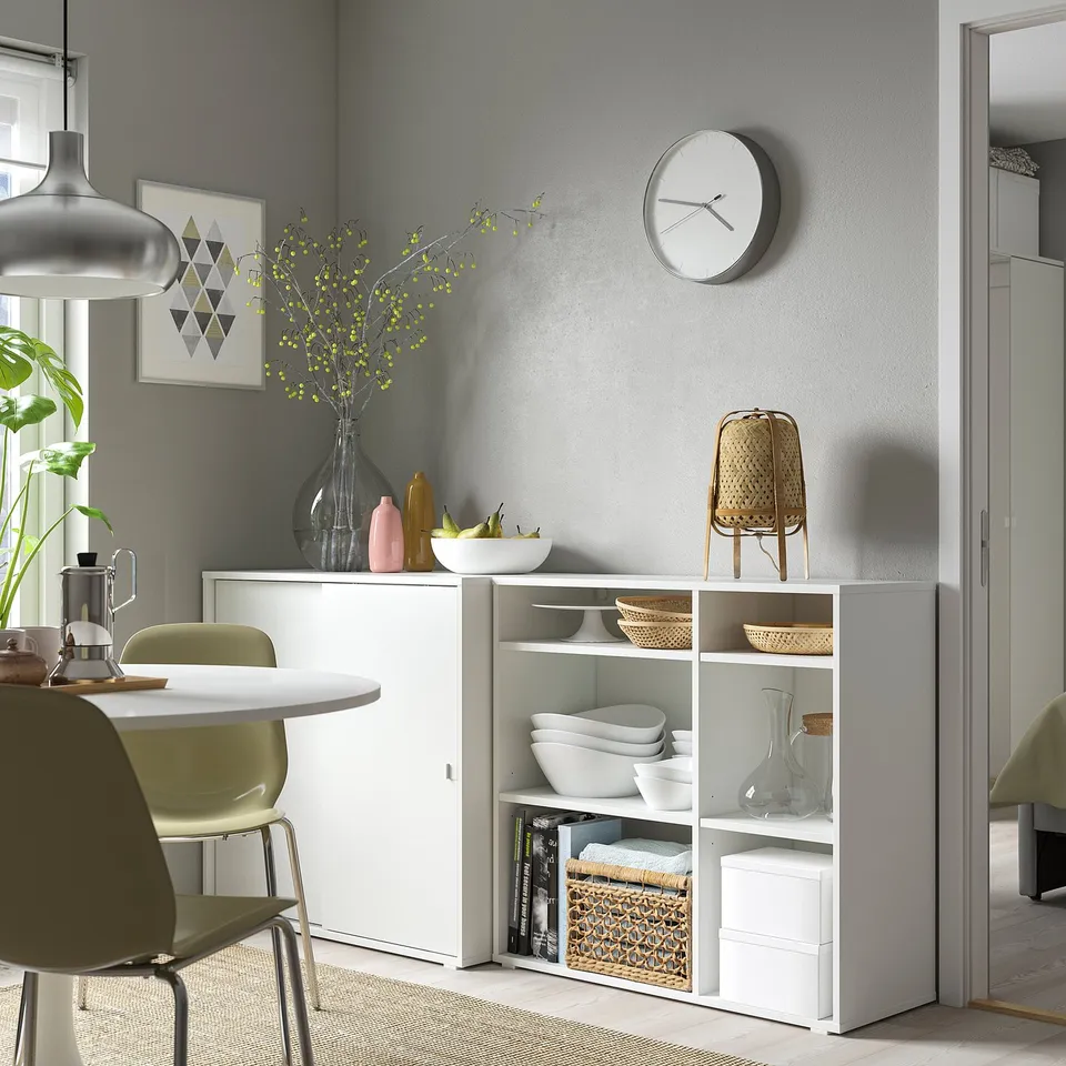 Modern dining room featuring white VIHALS storage units with sliding doors, open shelves, and decorative items.