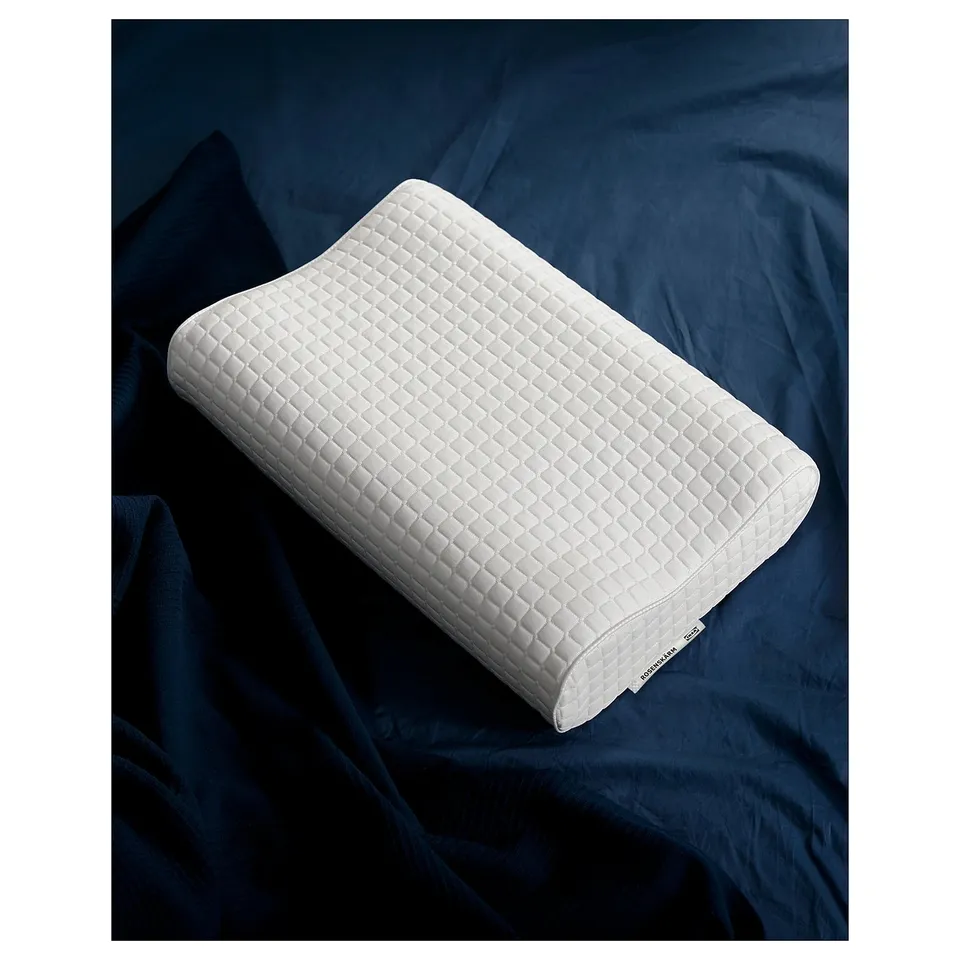 White ergonomic pillow by rosenskarm on dark blue bed linen.