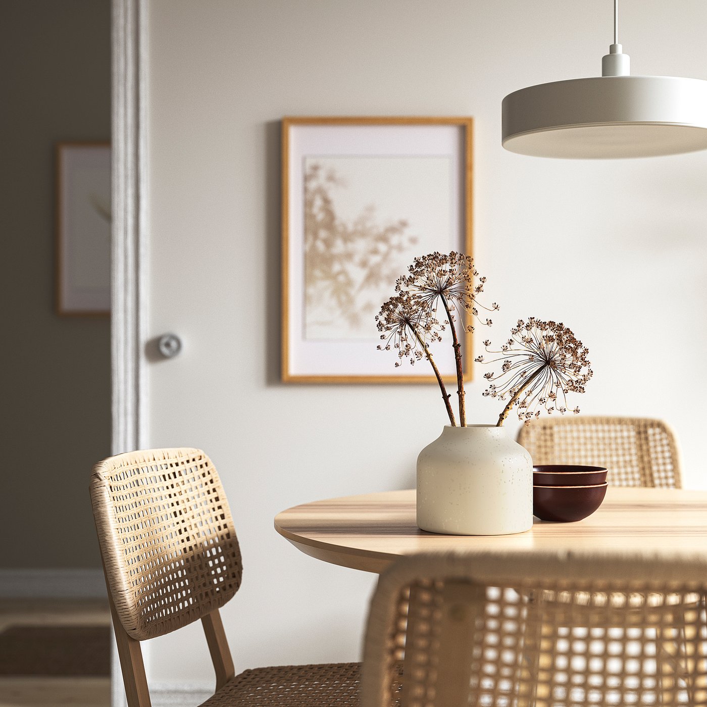 Small, white, matte glaze BLODBJÖRK vase sits on light wood table between beige wicker chairs, showcasing dried flowers.