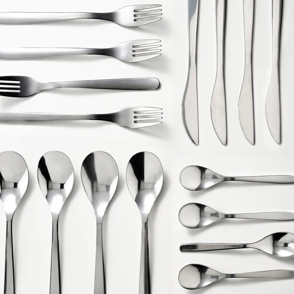 Shiny, organised cutlery set - forks, spoons, knives all polished, stainless steel; ready for use.