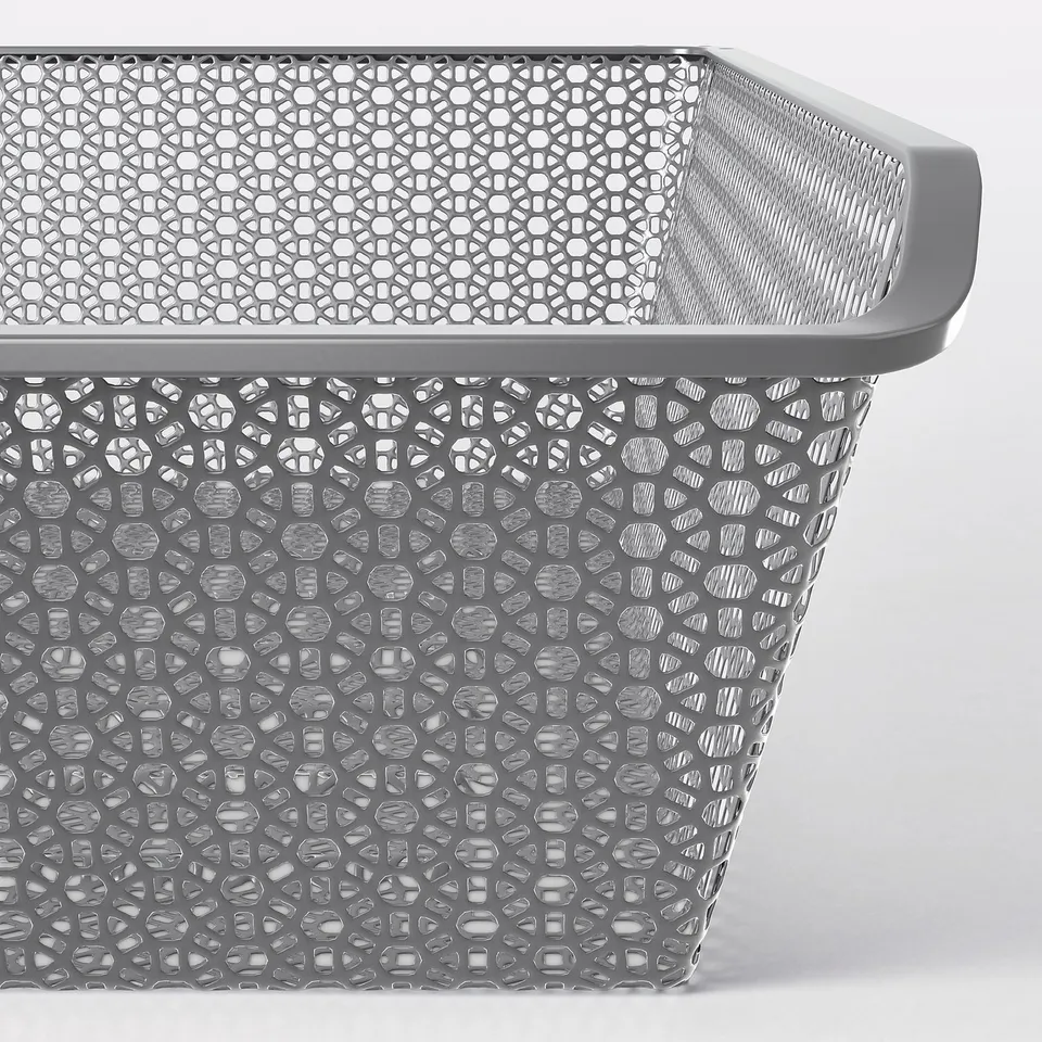Close-up of KOMPLEMENT metal basket with hexagonal pattern; grey colour, showing fine mesh design and sturdy construction.