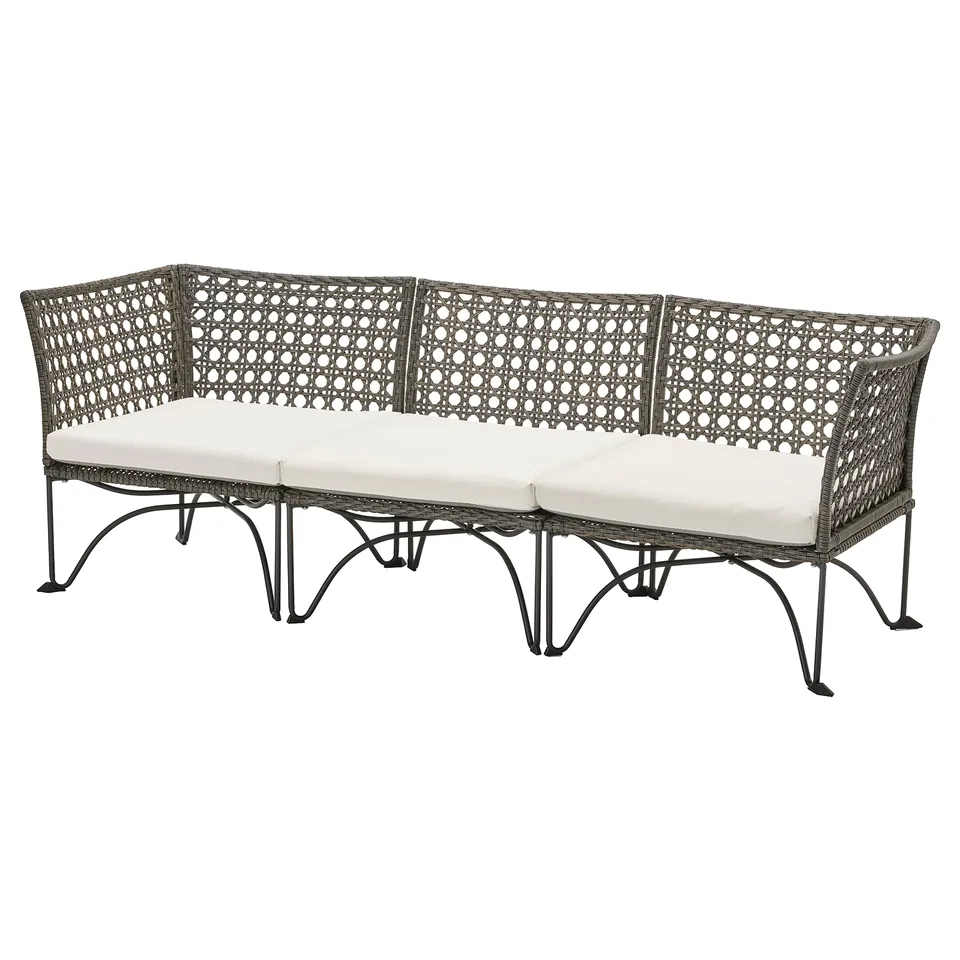 JUTHOLMEN outdoor sofa, grey, curved, wicker design with white cushions.