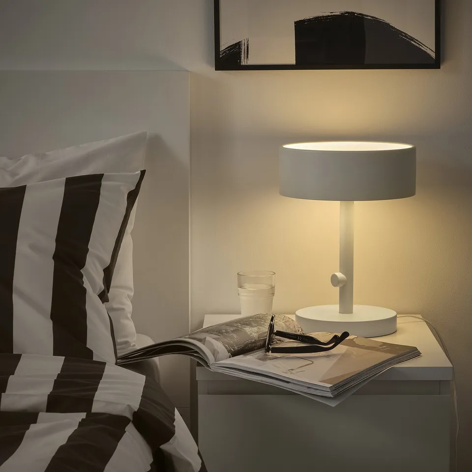 Modern bedroom with NYMÅNE lamp & striped pillows.