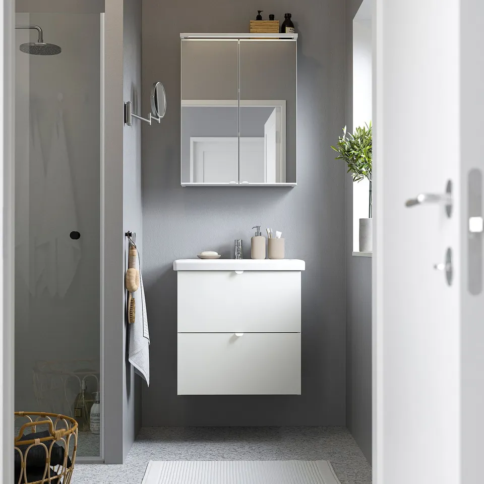 Modern bathroom with ENHET vanity, mirror cabinet, wall-mounted sink & plant.