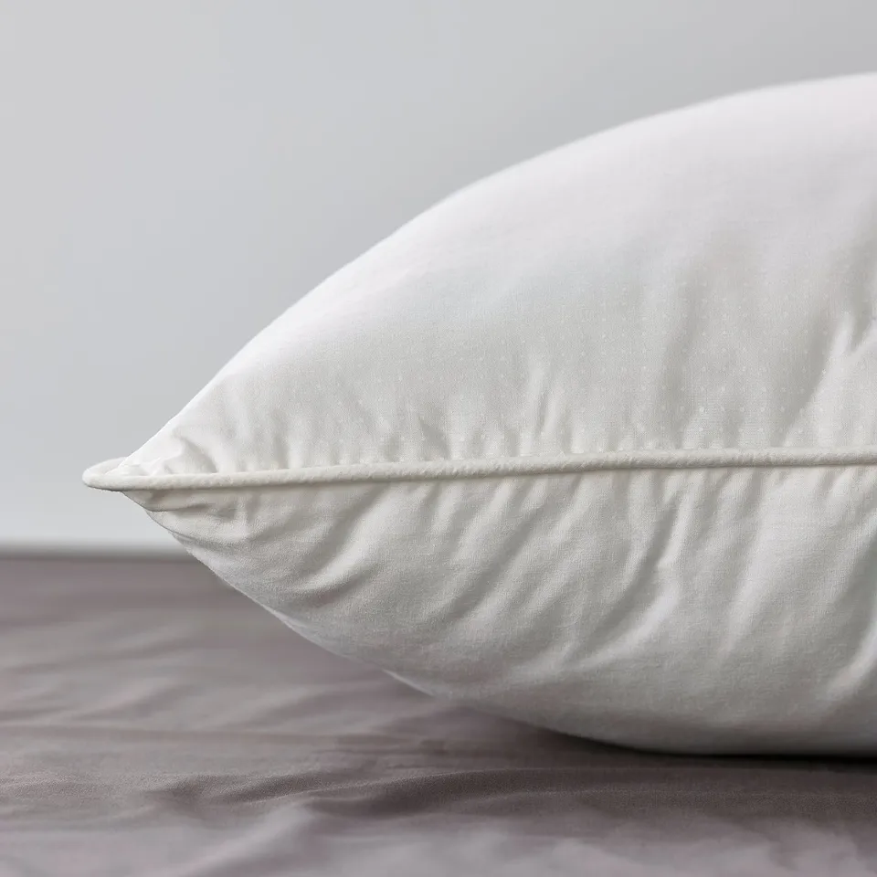 White pillow on bed, high-quality, supportive, breathable fabric.