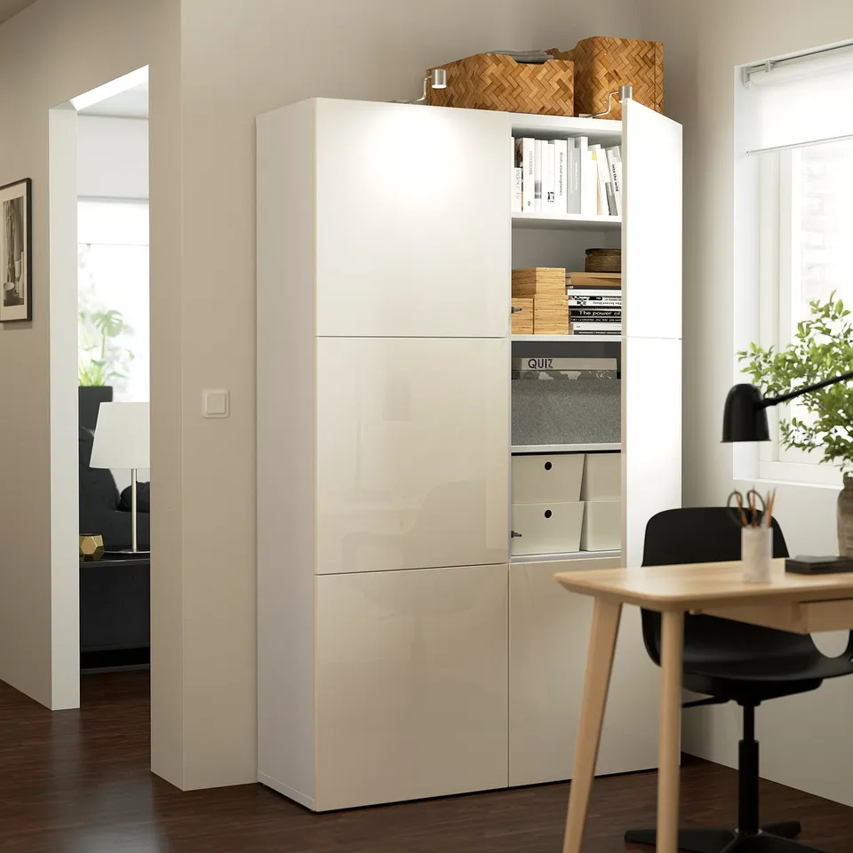 White BESTÅ storage unit with open doors revealing storage boxes and files. The adjustable shelves and soft-close hinges.