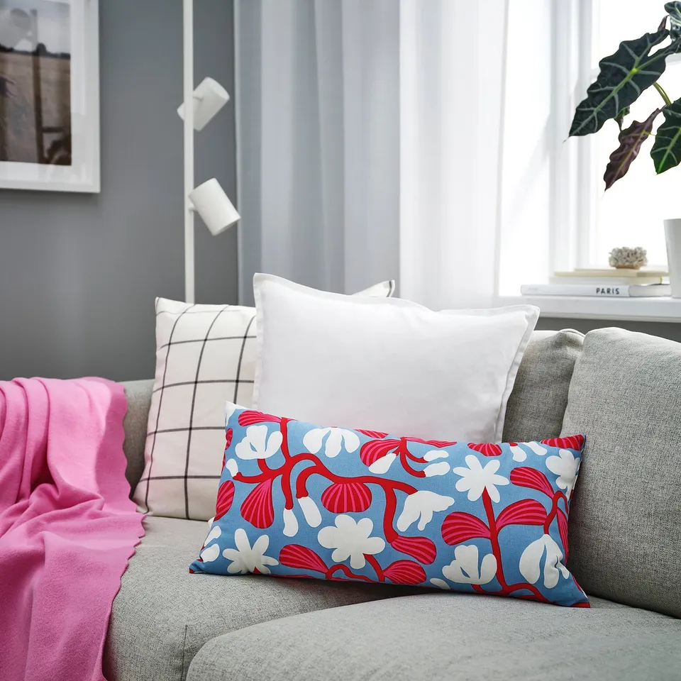 Blue & red floral throw pillow on grey sofa