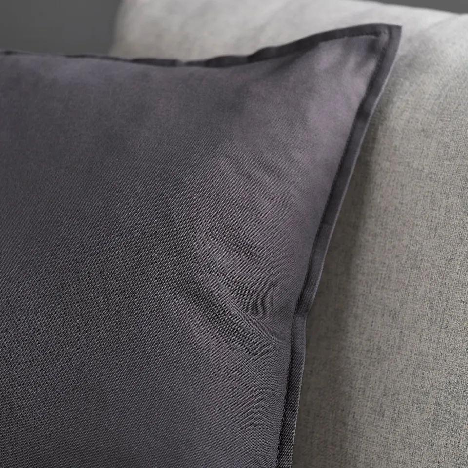 Dark grey cushion with smooth, high-quality fabric; neatly finished edge visible.