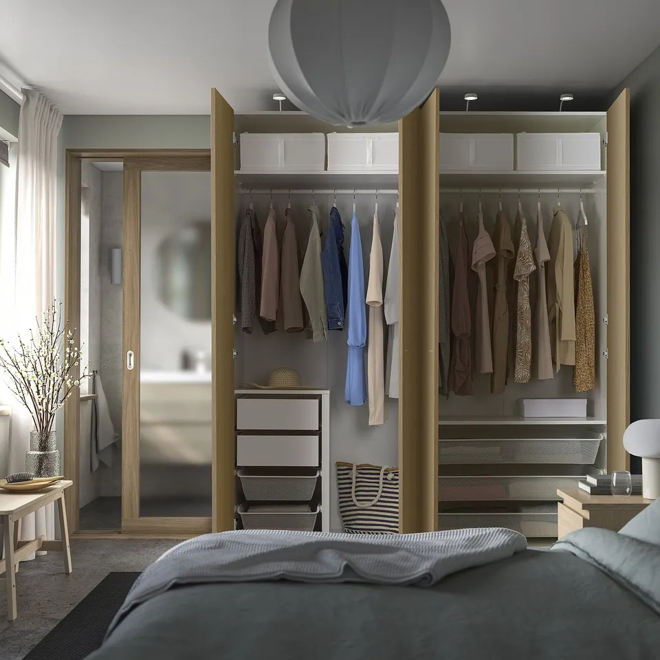 Organised bedroom with large wardrobe, mirrored doors, lights. Bed partially visible.