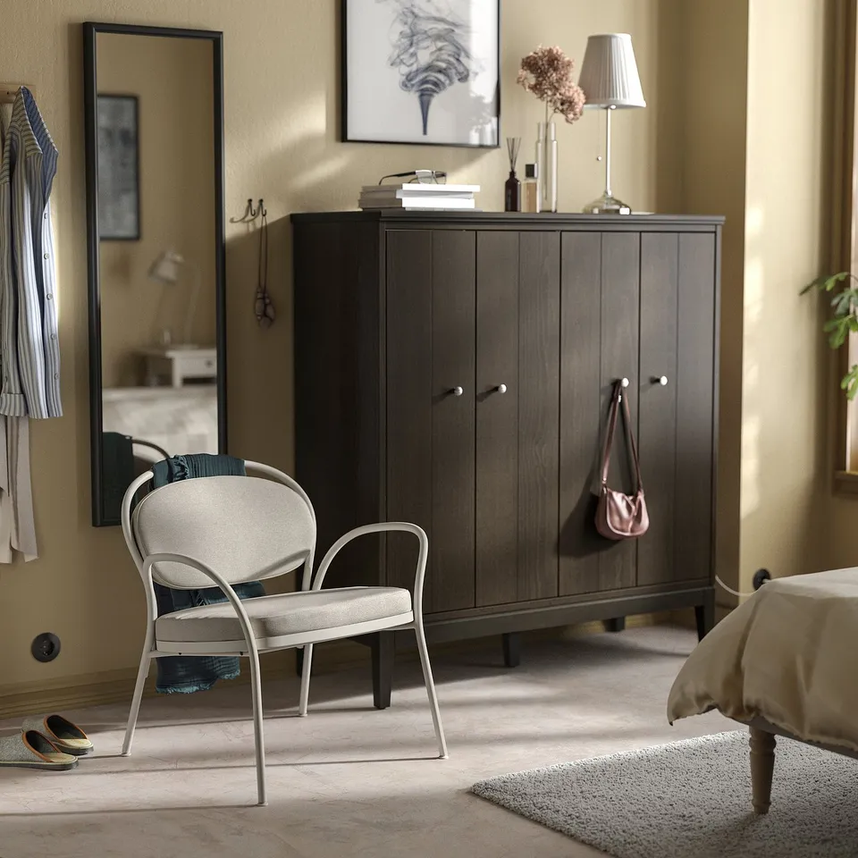 ISMANTORP chair in beige fabric. Slim, rounded frame; generously cushioned seat & back. Smaller than storage unit, fits well in cosy spaces.