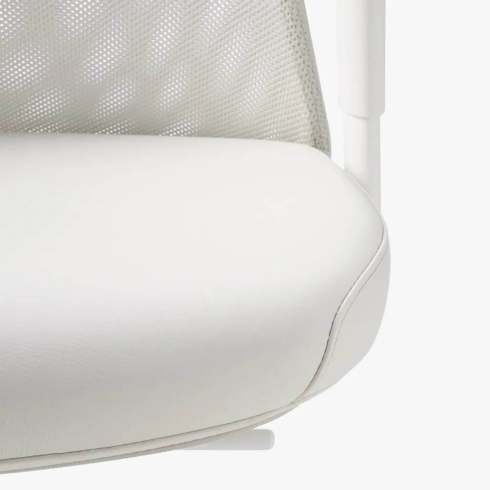 Ergonomic office chair close-up: white leather seat & mesh back, showing quality craftsmanship & comfortable design.