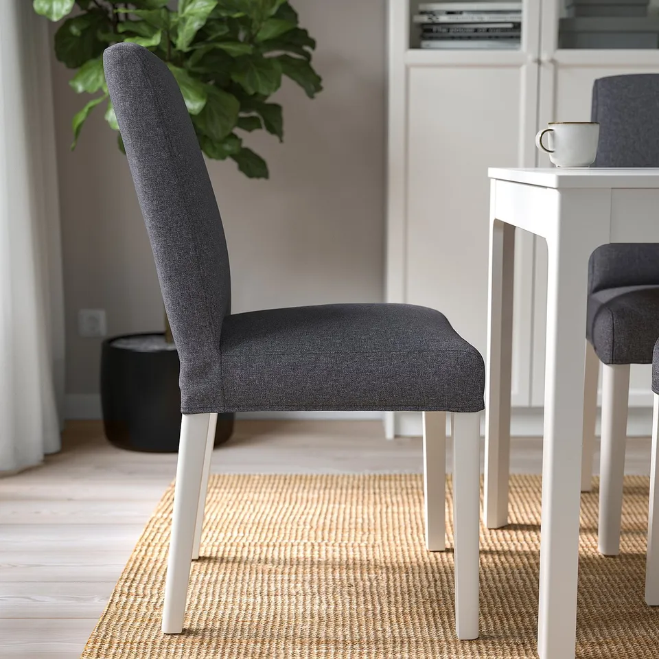 Modern dining chair with grey cover and white legs. Its part of the bergman collection, noted for comfort and ease of cleaning.