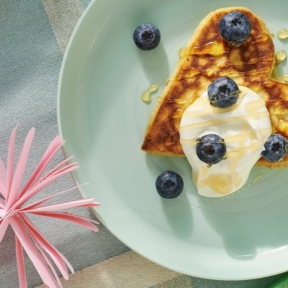 Light green kids plate with pancake, blueberries, and yoghurt. High edge, sturdy, impact resistant.