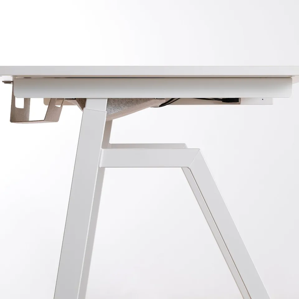 Modern sit-stand desk in white, sleek design, adjustment controls visible, sturdy frame.