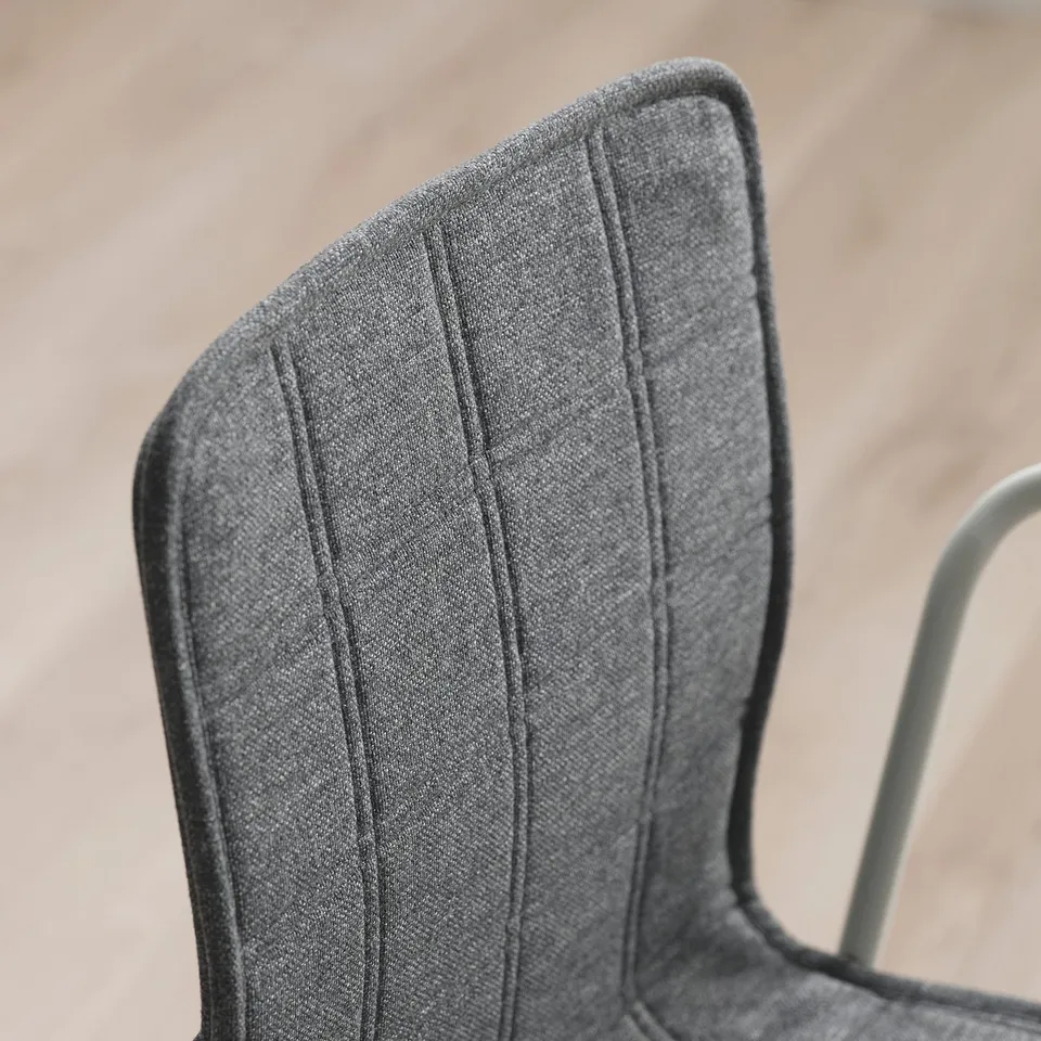 Close-up of modern, sturdy conference chair backrest. Soft, textured grey fabric with clean stitching. Elegant design for comfort and durability.