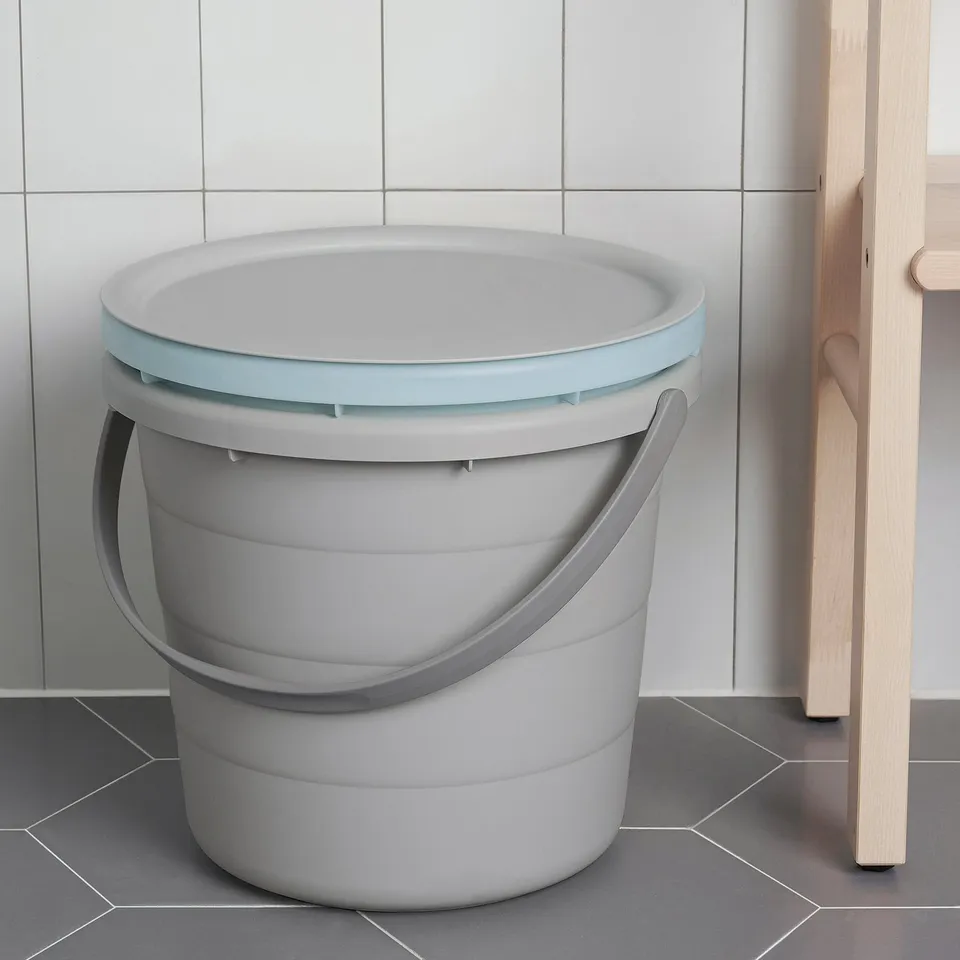 Grey plastic PEPPRIG bucket with light blue lid and handle sits on tiled floor. Suitable for carrying water or storing items with secure lid.