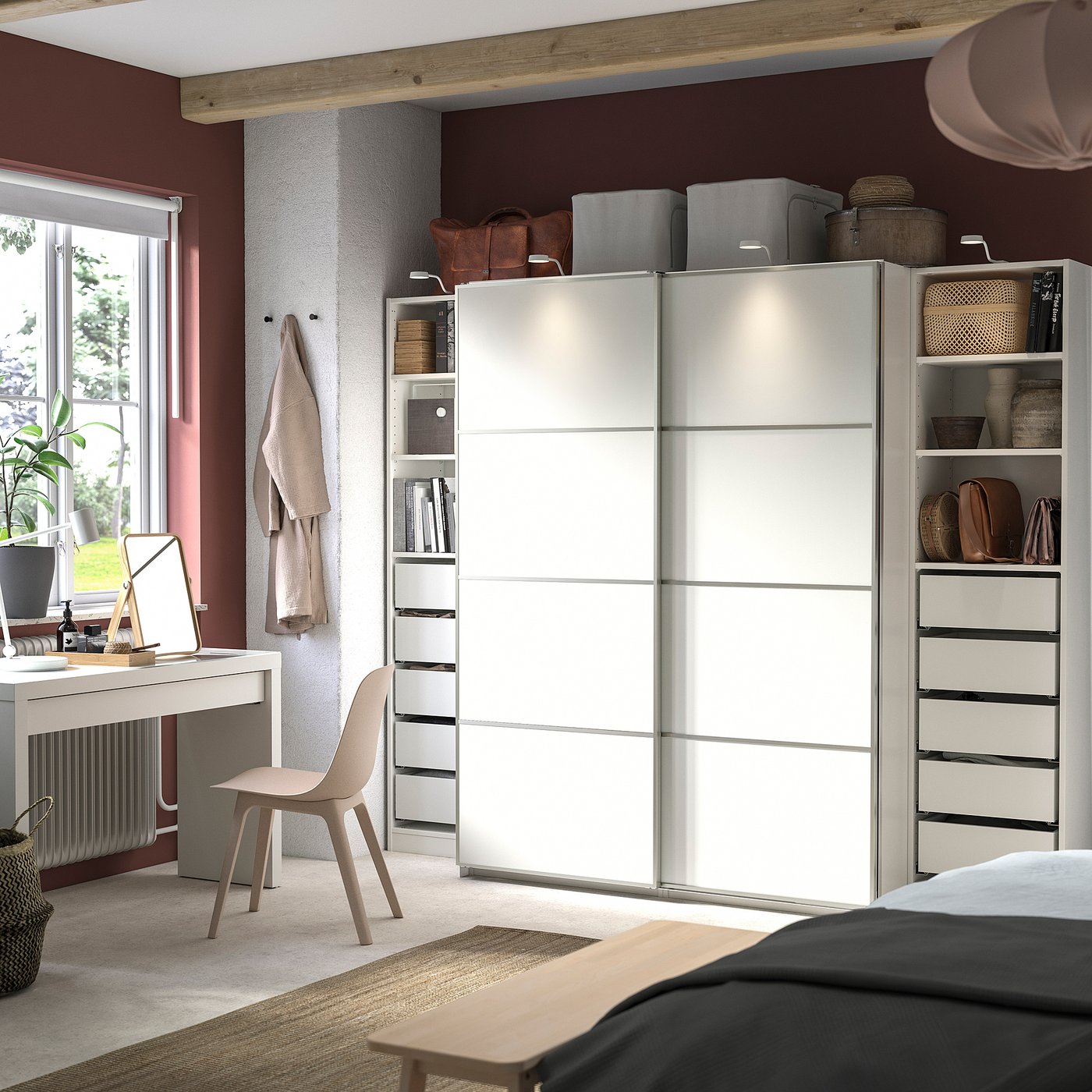 Modern bedroom with large white sliding door wardrobe, beige chair, desk, and rug, featuring organised shelves and drawers.