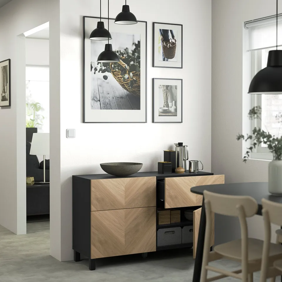 Dining room with dark wood sideboard, stone bowl, and framed photos above.