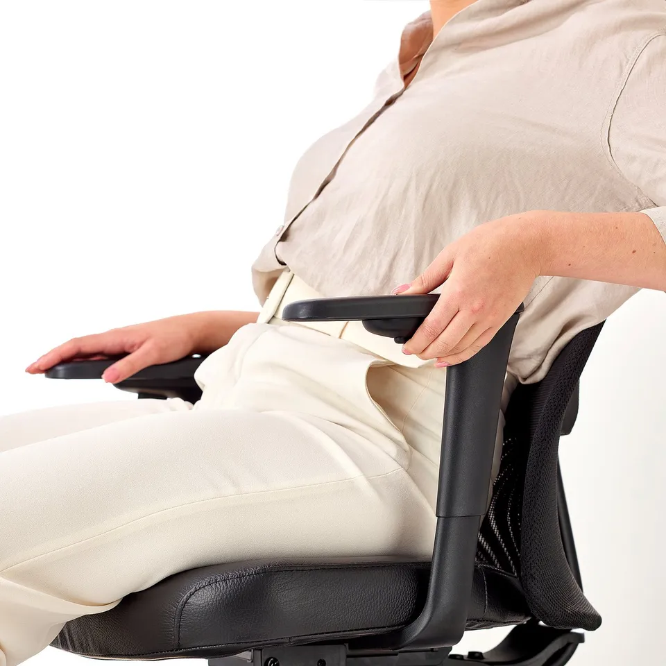 Adjusting ergonomic office chair armrests for comfort.