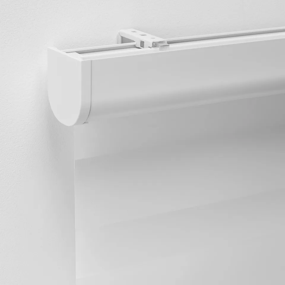 Close-up of modern white dual roller blind mechanism, showcasing sleek design and precision engineering.