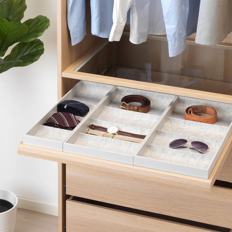 Wooden drawer with felt trays holds accessories like belts and watches, slides open smoothly, good for organising.