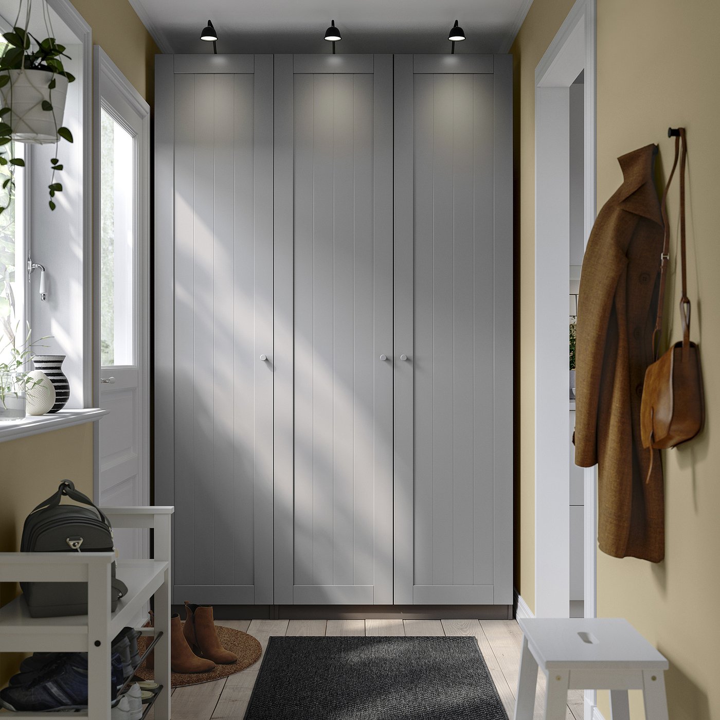 Modern entryway with PAX wardrobe, white furniture, sleek décor, and coats.
