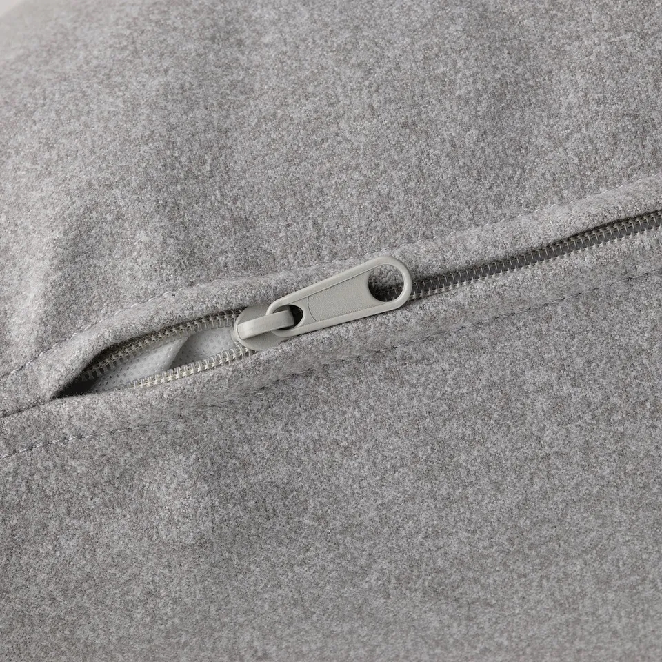 Close-up of a grey zip on soft, high-quality fabric.