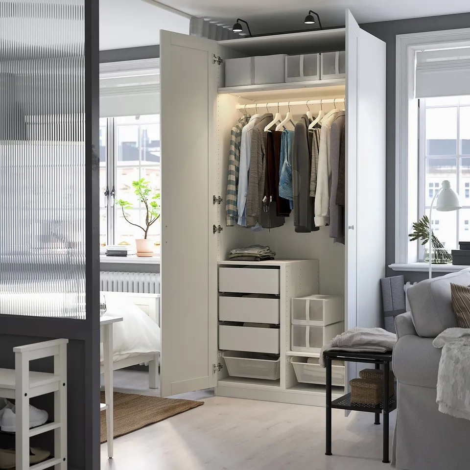 Open wardrobe displaying clothes and drawers, showcasing interior storage solutions.