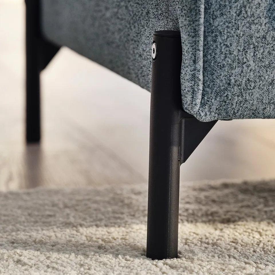 Modern sofa with sleek black metal legs and plush grey fabric.