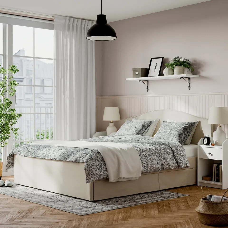 Beige RAMNEFJÄLL bed with pattern, nightstands, pink wall, decorated shelf, large window.