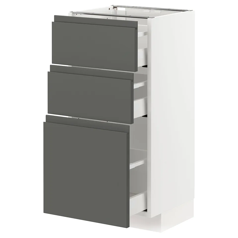 Modern kitchen cabinet, white METOD system with dark grey voxtorp drawers, three drawers visible, sleek design.