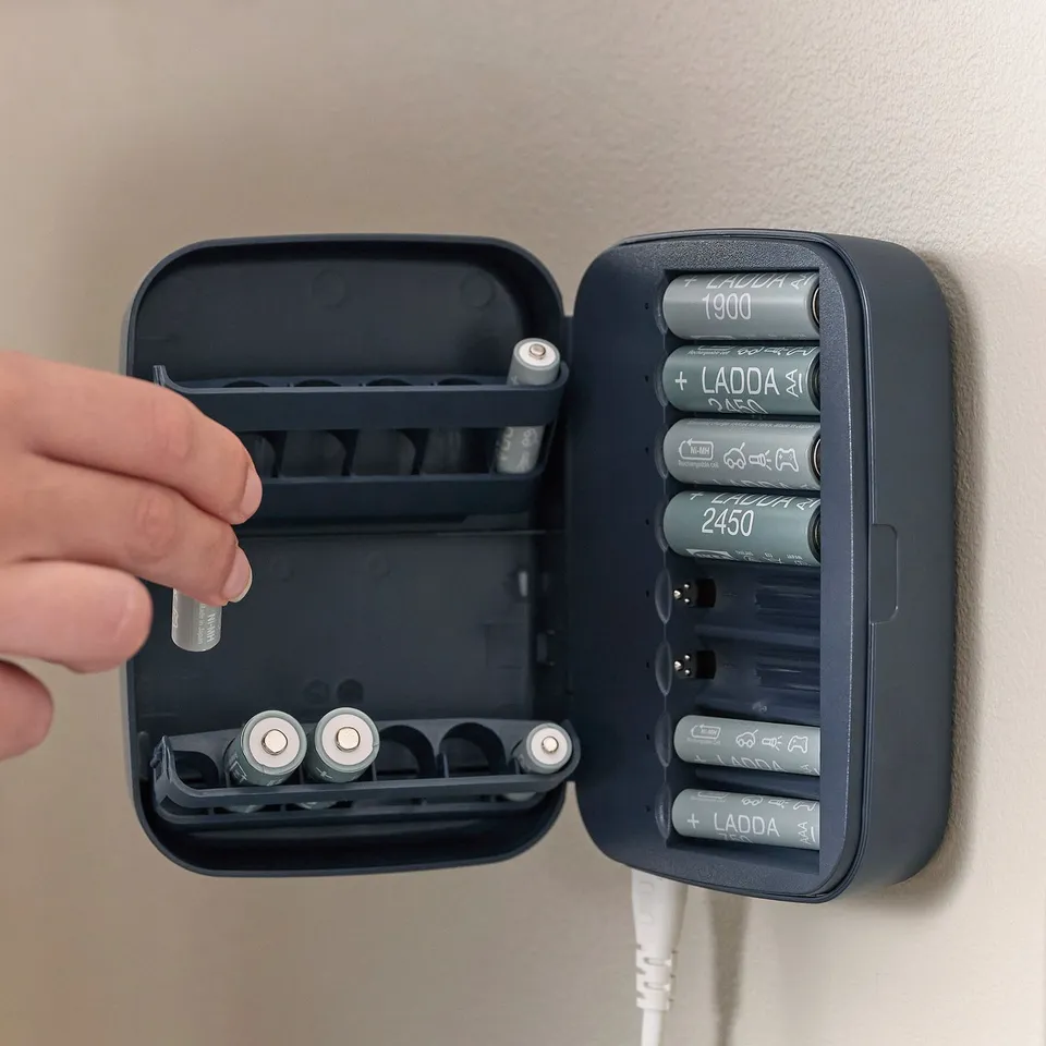 Hand placing battery into LITOSFÄR charger, which stores and charges batteries.