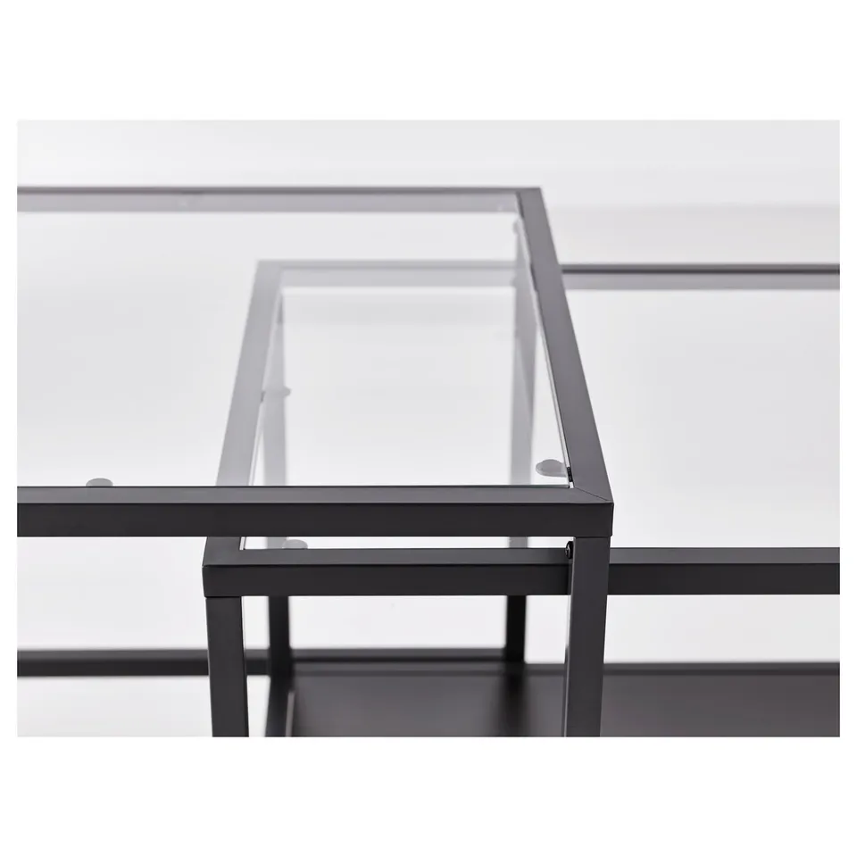 Modern metal and glass nesting tables; one under the other, sleek design.