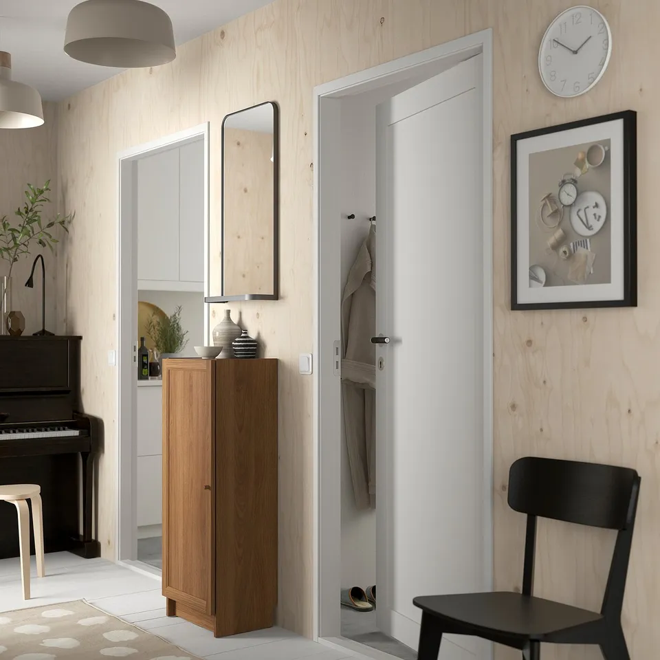 Modern hallway with BILLY bookcase, open closet, chair, piano, pendant lights.