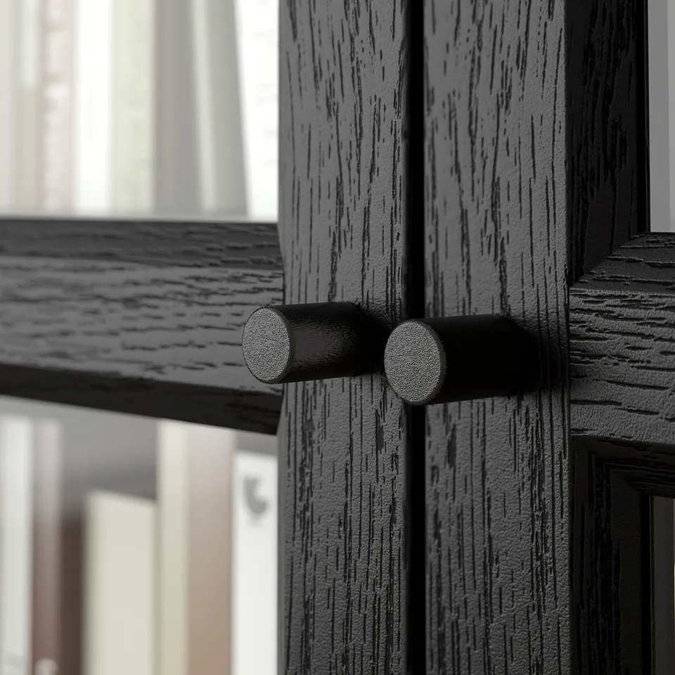 Close-up of dark wooden BILLY bookcase door with modern cylindrical handles.