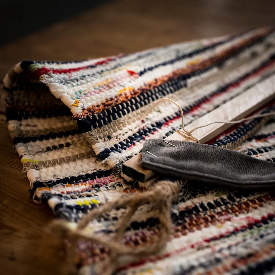 Colourful TÅNUM rug on floor, multicolor stripes, rectangular shape, handwoven cotton.