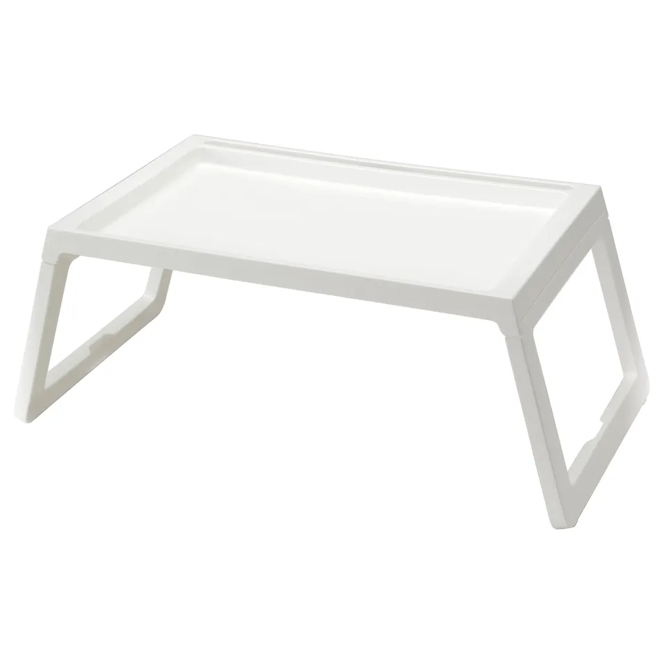 A white KLIPSK foldable bed tray. It a flat rectangular surface with built-in tablet support and a charging hole, supported by four angled legs.