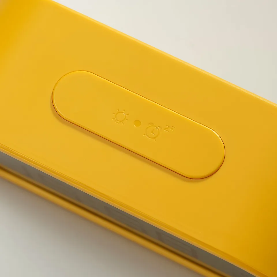 Yellow alarm clock with icons, showing time and light settings.