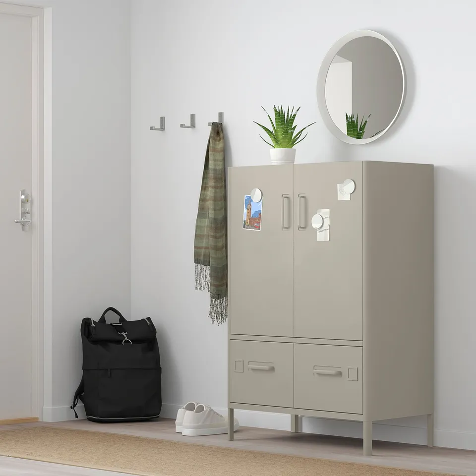 IDÅSEN beige cabinet with metal accents, 2 doors & 2 drawers, silver handles, against light wall.