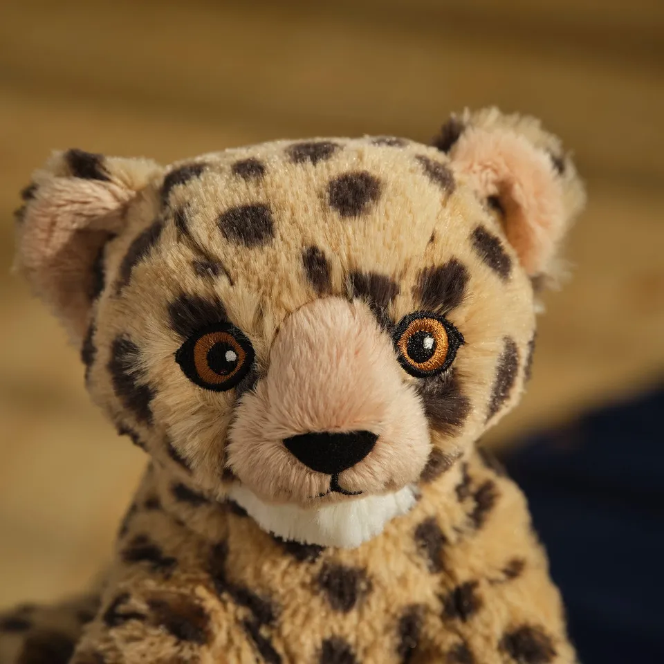 Soft cheetah cuddly toy with large eyes and spotted fur.