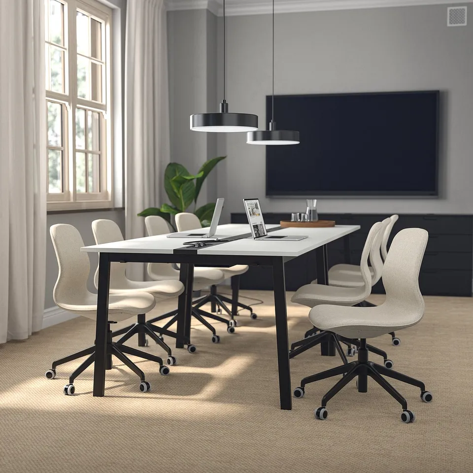 MITTZON white conference table in room with chairs, plants, and tv. Modern design, spacious and well-lit.