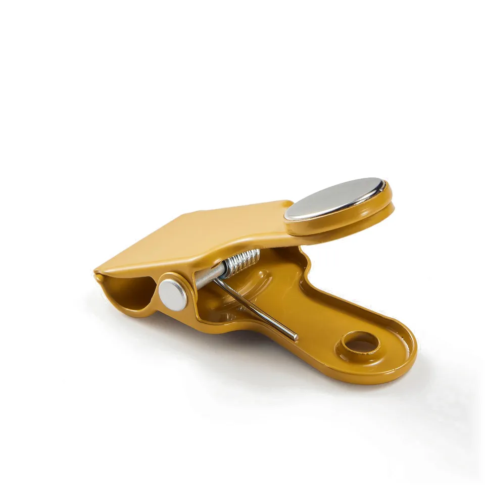 Yellow multi-use kitchen clip with magnet and metal spring. Suitable for sealing bags and attaching items to magnetic surfaces.