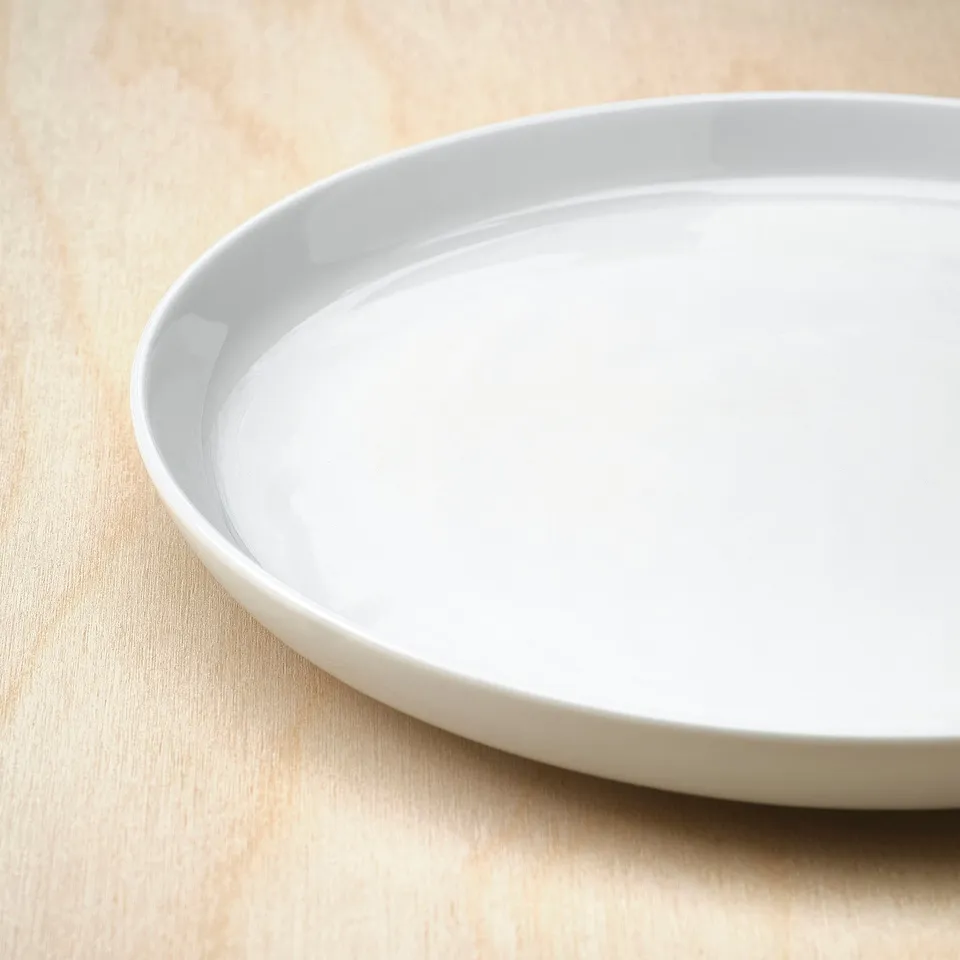 White side plate on light table. Smooth edge, clean design.