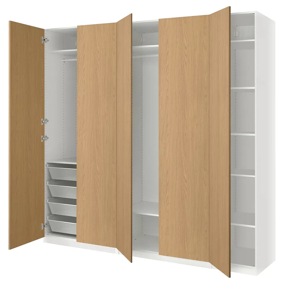 An IKEA PAX wardrobe with light oak doors and white interiors. It has adjustable shelving and hanging space.