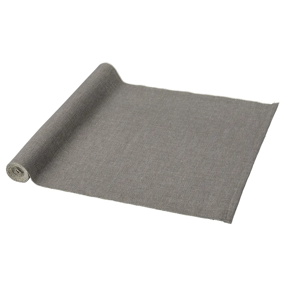 Grey rectangular table runner, rolled at one end, made of 100% cotton.