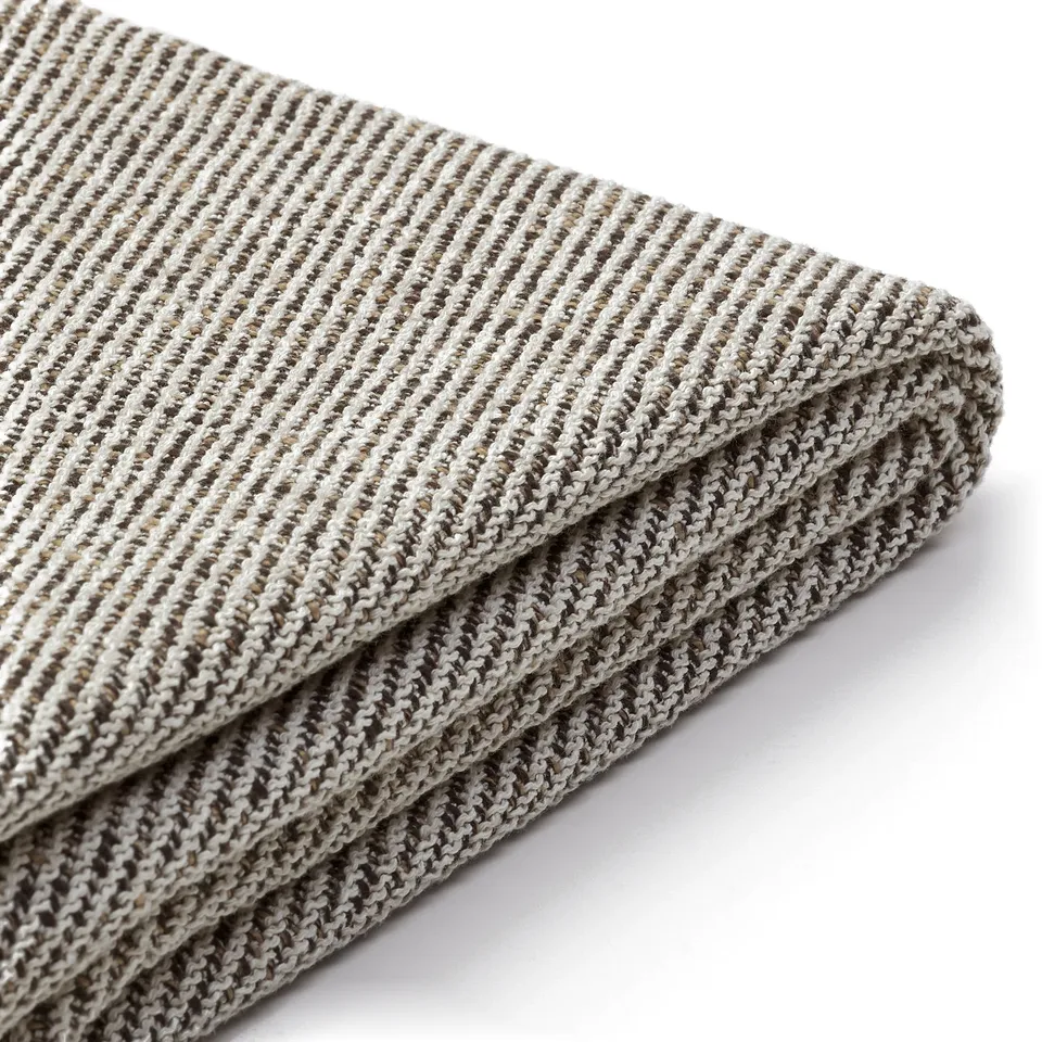 Soft, striped fabric blanket folded neatly, showcasing quality texture and craftsmanship.