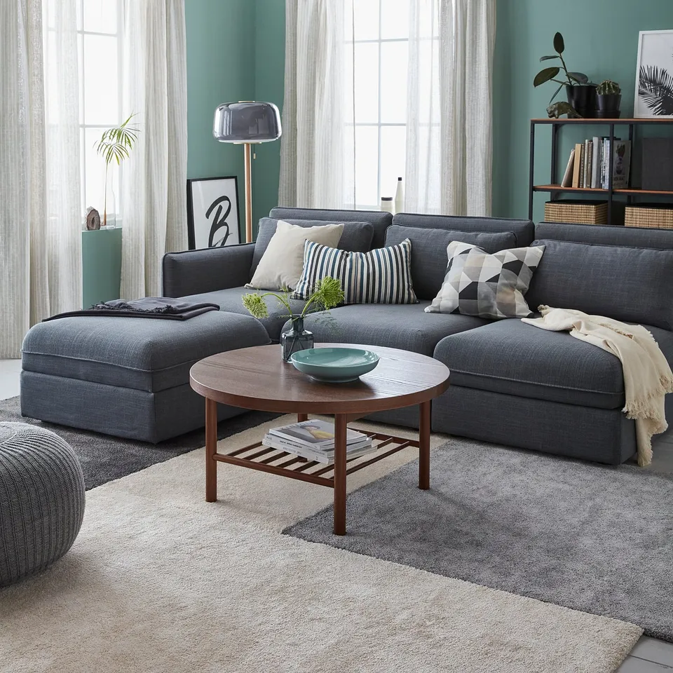 Modern living room with a grey STOENSE area rug, grey sectional sofa, wooden coffee table, and green walls.