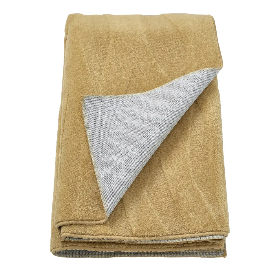 A folded, tan VÄXELFEL rug. Its rectangular with textures in soft yellow-brown and a non-slip back. The design is simple and functional.