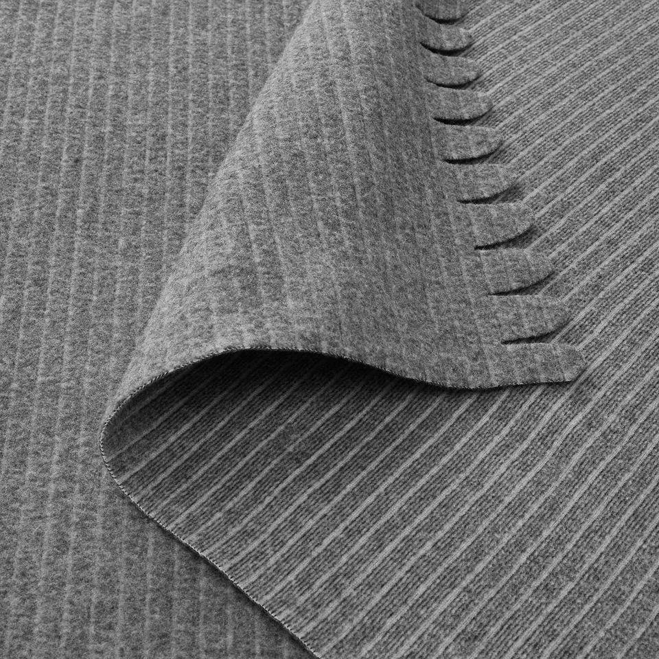 Soft, folded grey bedspread, showing texture and stitching.